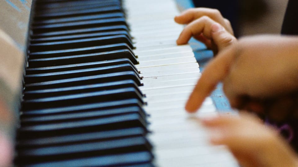 A child's hands on the keys of a piano