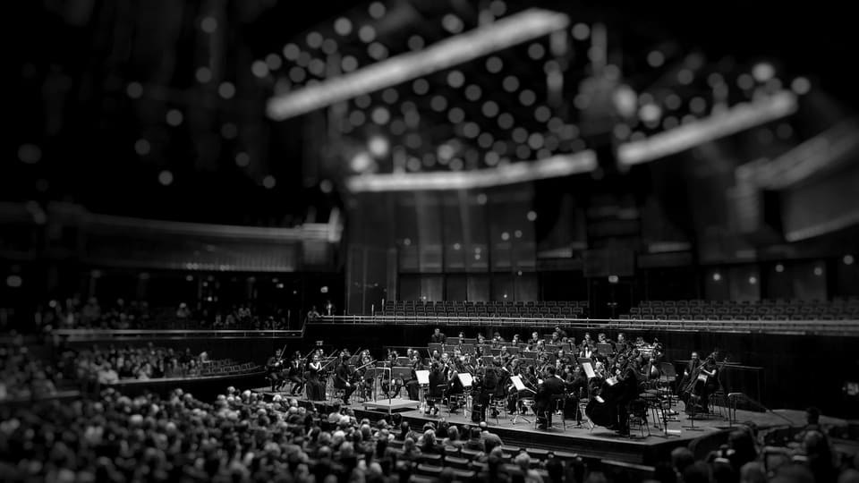 Black-and-white photo of an orchestra on a theatre stage