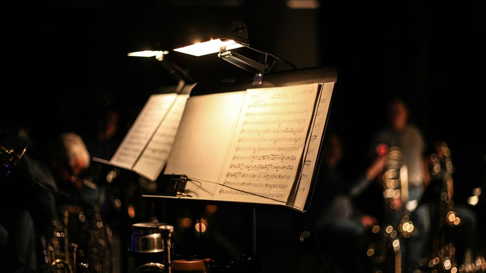 Music stands lit on a dark stage